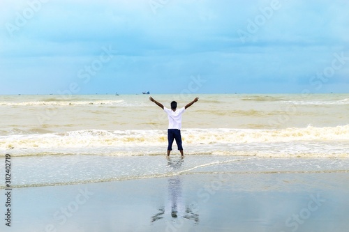Concept of success and achievement. The boy enjoying sunrise on world largest sea beach - cox bazar. Enjoy sunrise and sea waves. Coxbazar, Bangladesh / 2020.