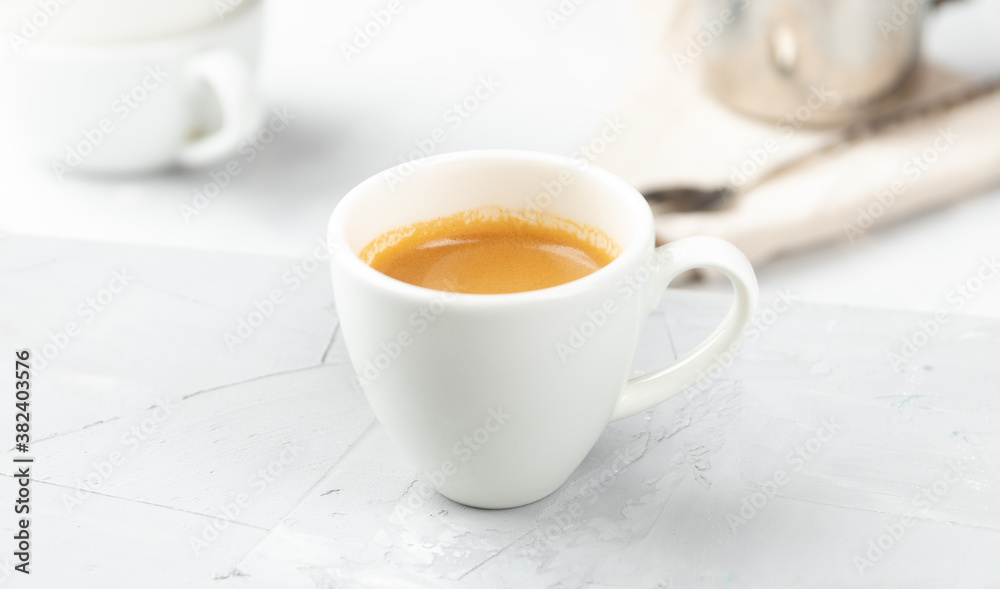 Small cup of hot espresso coffee on concrete background