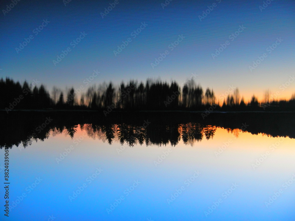 sunset on the lake with reflection 