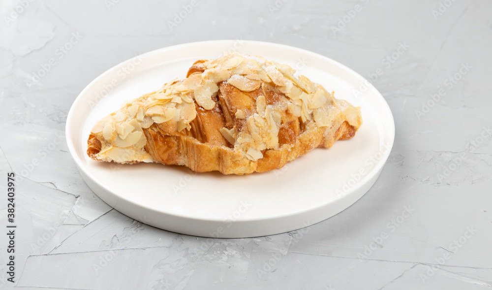 Baked fresh fragrant croissant with almonds, homemade baked goods on concrete background Baked fresh fragrant croissant with almonds, homemade baked goods on concrete background