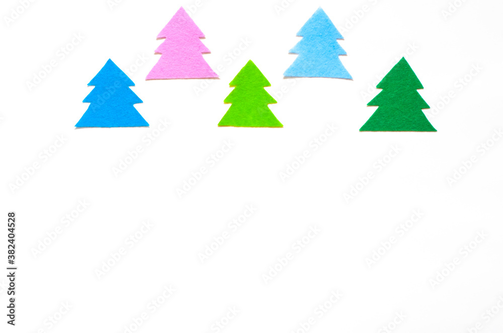 Fototapeta premium Colored silhouettes of Christmas trees on a white background, copy space