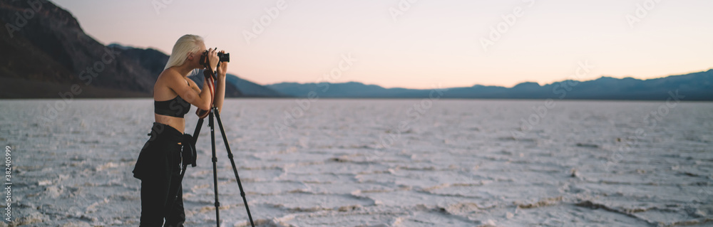 Anonymous female traveler taking photo of landscape in desert
