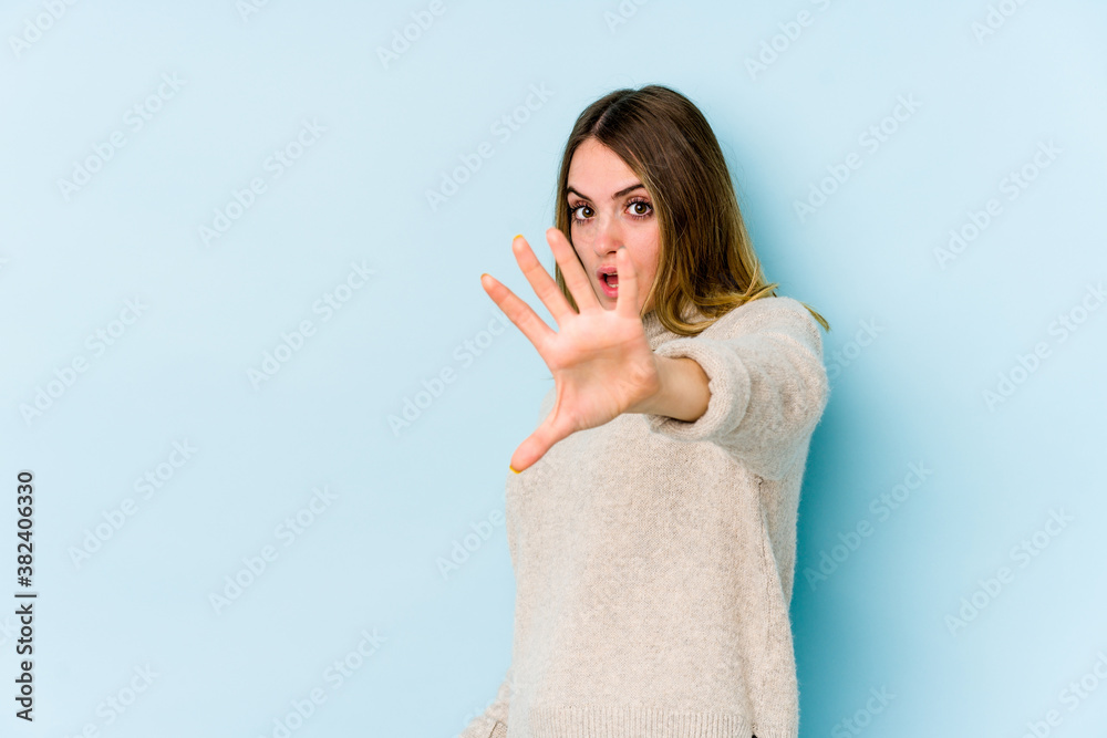 Young caucasian woman isolated on blue background being shocked due to an imminent danger Young caucasian woman isolated on blue background being shocked due to an imminent danger
