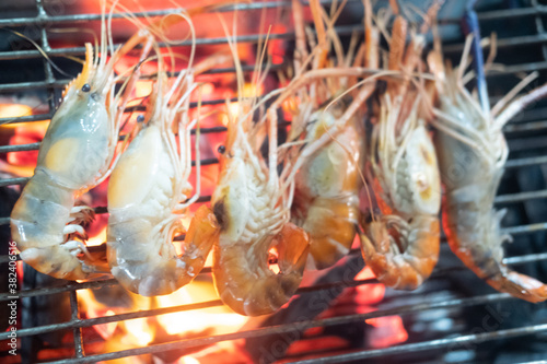 Grilled shrimps on barbecue flaming grill.