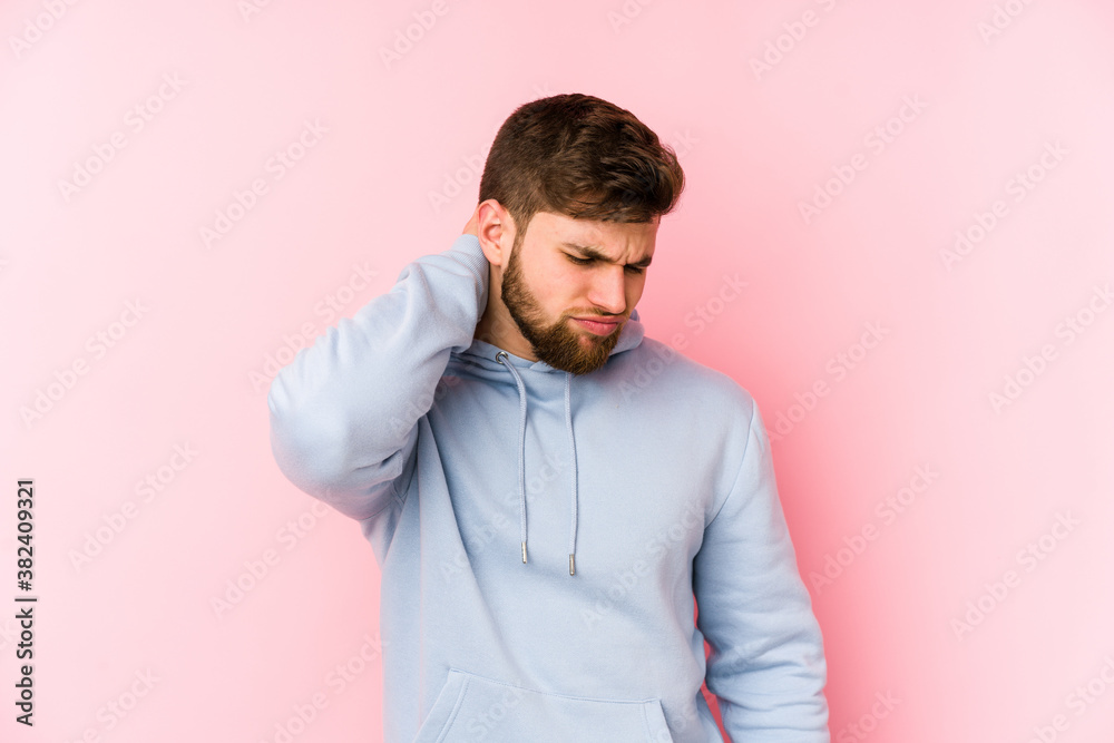 Young caucasian man isolated on pink background suffering neck pain due to sedentary lifestyle. Young caucasian man isolated on pink background suffering neck pain due to sedentary lifestyle.