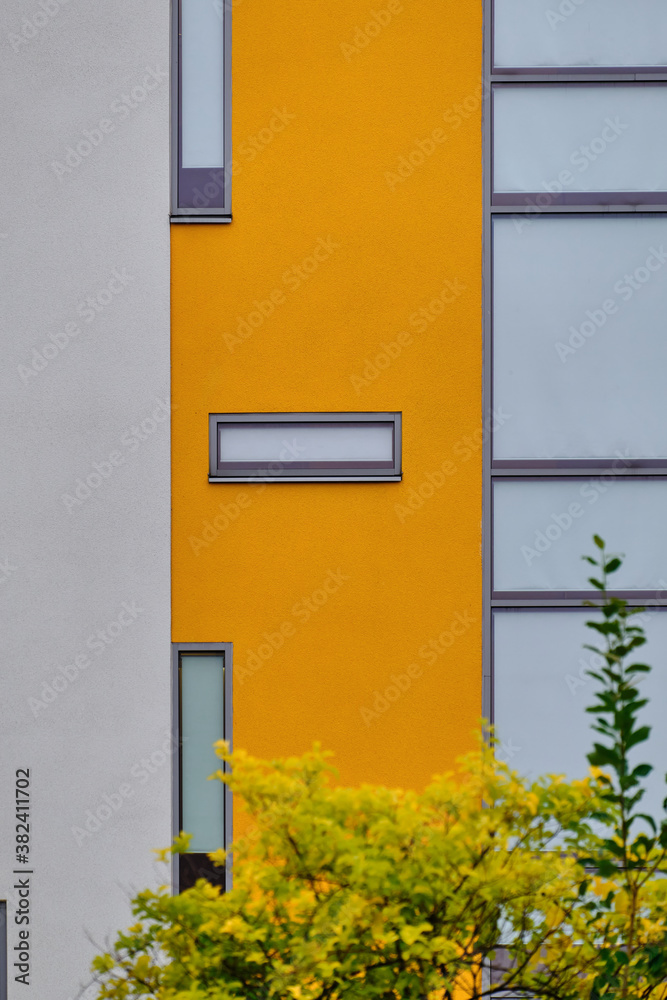 The modern yellow and white facade of the apartment building in Finland. The modern nordic architecture.