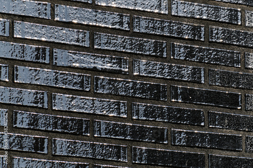 Obraz na płótnie The black glossy brick wall of a modern apartment building. Modern nordic architecture. Pattern of brick wall. w salonie