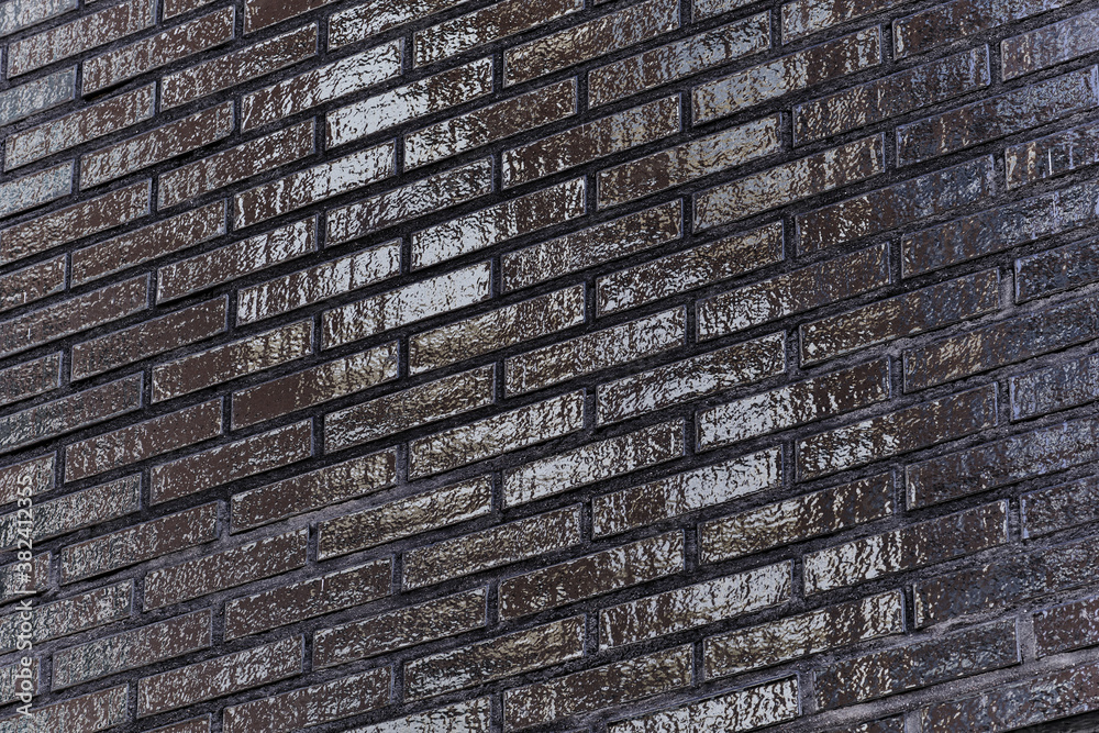 The black glossy brick wall of a modern apartment building. Modern nordic architecture. Pattern of brick wall.