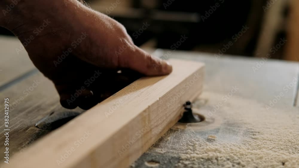 Carpenter works with a manual electric milling cutter. Woodworker processes a wooden board. Carpentry, craftsmanship, Handicrafts.