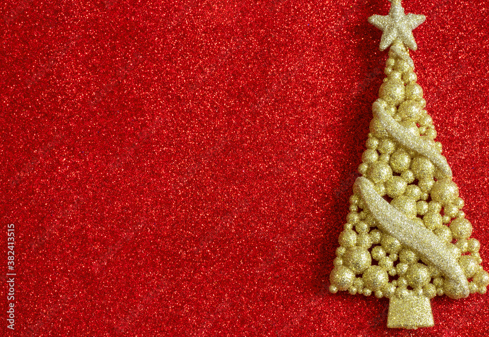 Shiny Golden decorative figure of a Christmas tree on a red background. Christmas background. Empty space for copying.