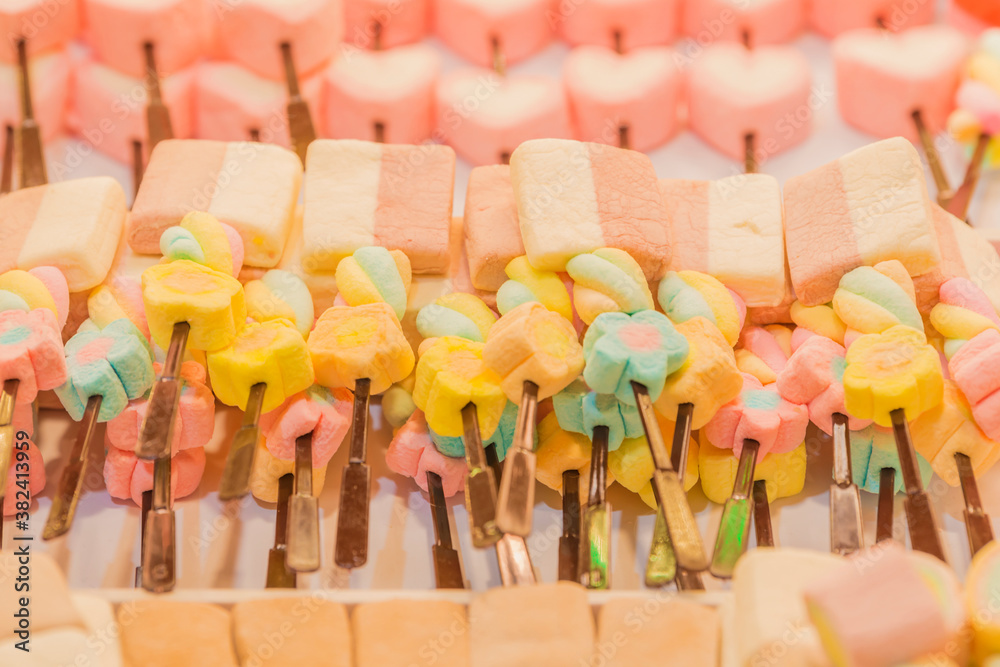Naklejka premium Different colorful marshmallow on sticks. (Select focus)