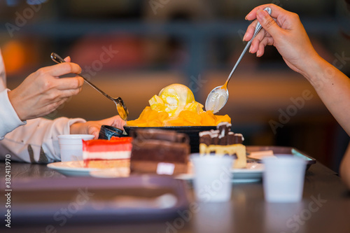 Spoon scooping korean dessert with mango to eat. (Select focus)