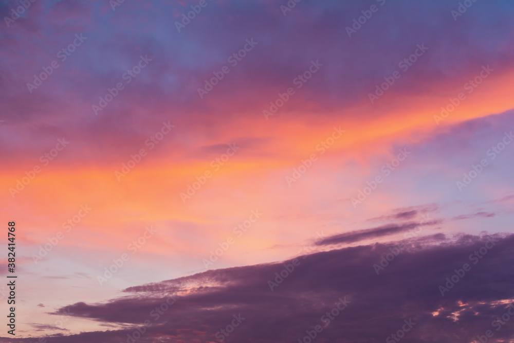 View of the sky in the evening at sunset with a dark cloud and bright orange glow from the sun. Landscape concept, background.