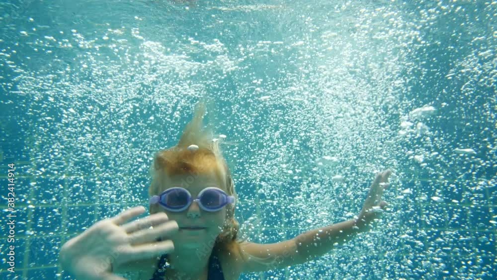 6 year old girl jumping into a pool in a resort