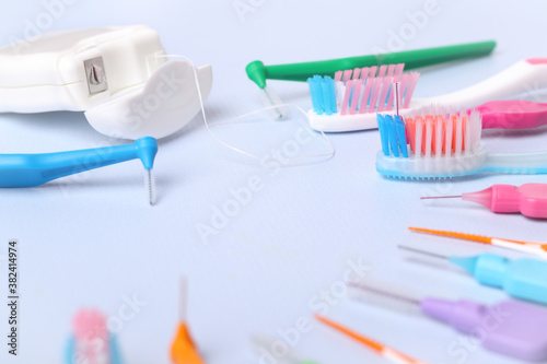 Toothbrushes, dental floss and interdental toothbrushes on blue background, small depth of focus. Dental and orthodontic concept.