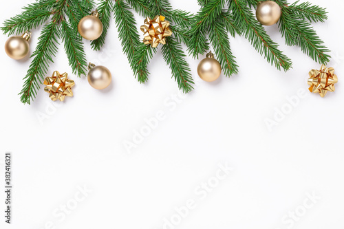 Christmas composition with fir tree branches and golden christmas balls on white background. Top view. Copy space