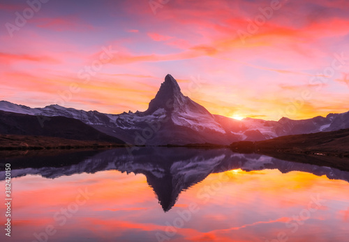 Picturesque landscape with colorful sunrise on Stellisee lake. Snowy Matterhorn Cervino peak with reflection in clear water. Zermatt, Swiss Alps photo