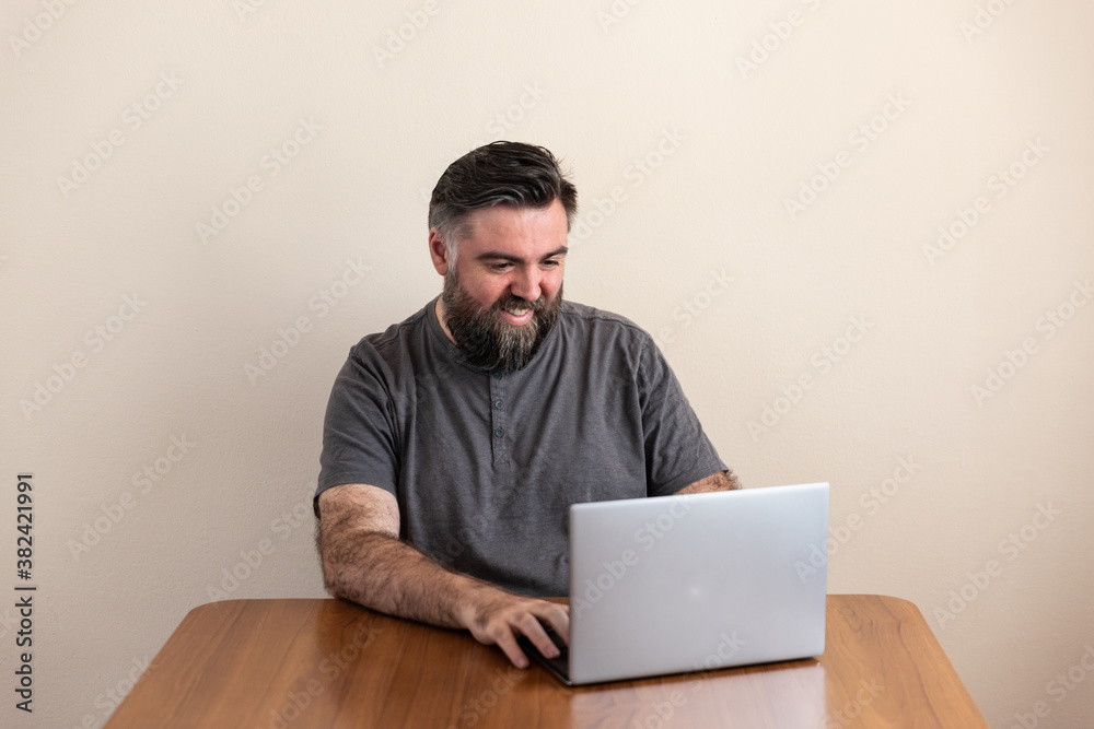 man using a laptop placed on a table man using a laptop placed on a table