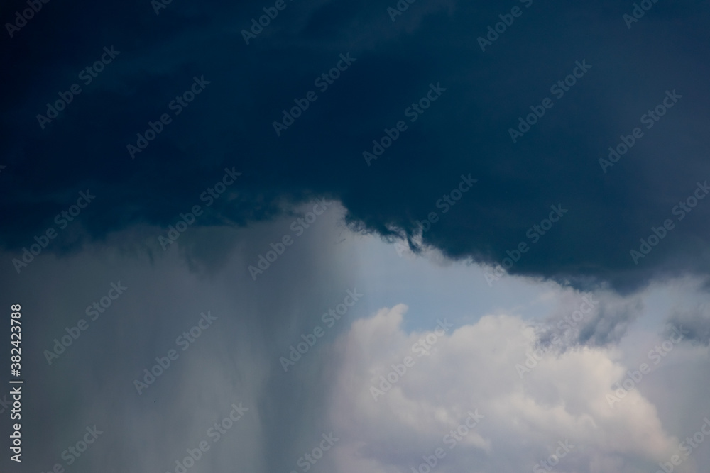 Obraz premium Dark storm clouds and gray gloomy clouds, a terrible natural phenomenon, rain from afar, view from the side