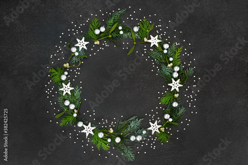 Konstfotografi Christmas & solstice wreath with star & silver ball decorations, mistletoe & cedar cypress fir on grunge grey background