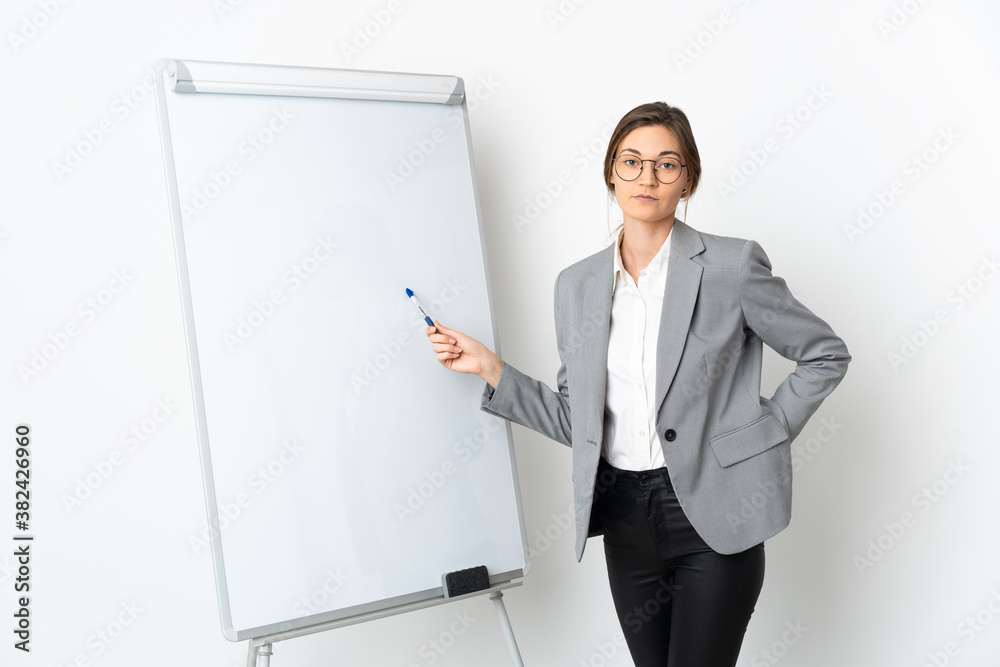 Young Ireland woman isolated on white background giving a presentation on white board and pointing it Young Ireland woman isolated on white background giving a presentation on white board and pointing it