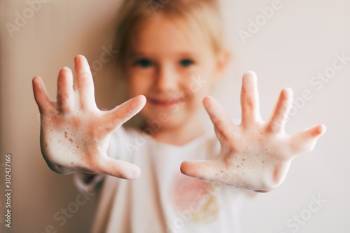 Smilling  little girl is washing hands.  Cute child showing soapy hands. Covid 19