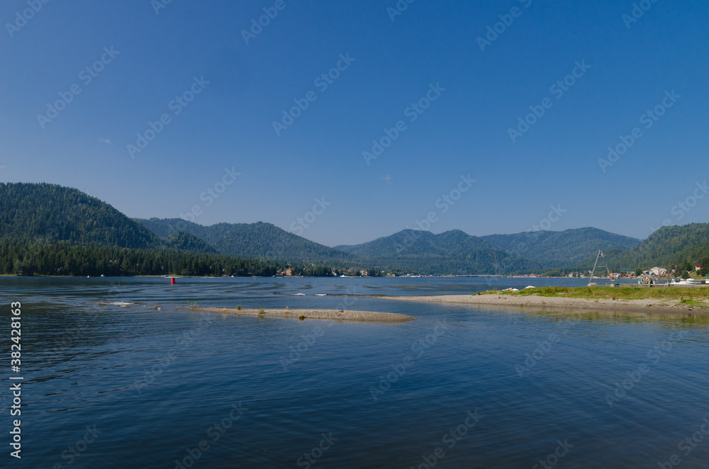 View of the lake surrounded by mountains on a sunny day