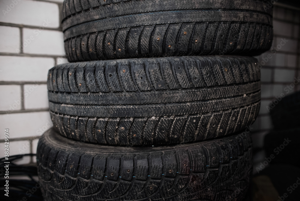 Used car tires against a brick wall. Worn tread of winter tires
Used car tires against a brick wall. Worn tread of winter tires