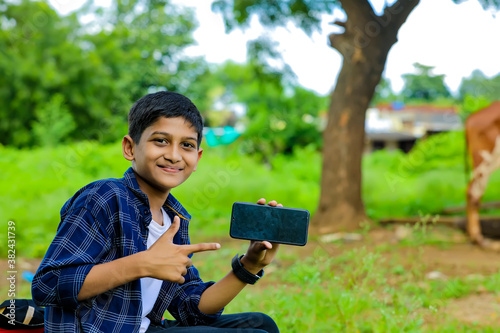 indian cute child showing showing smartphone