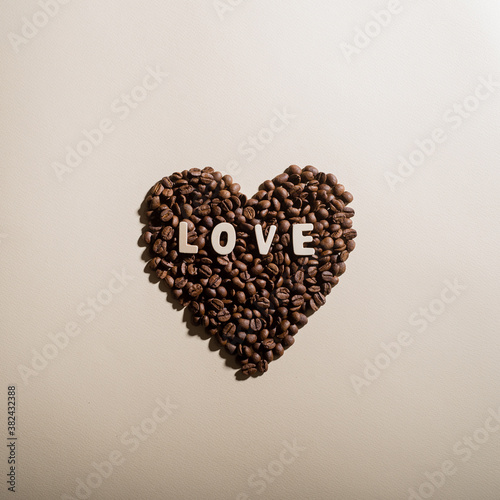 Coffee beans in the shape of a heart and the inscription love on a background