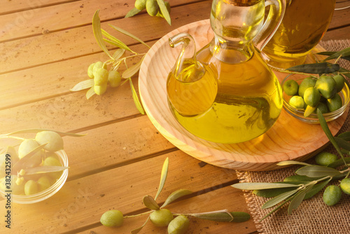 Homemade new harvest olive oil in container on wooden table