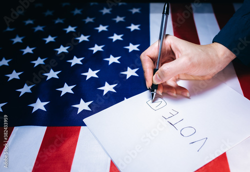 American flag. Elections in the USA. Woman putting tick on the paper for vote. Political changes in the country.