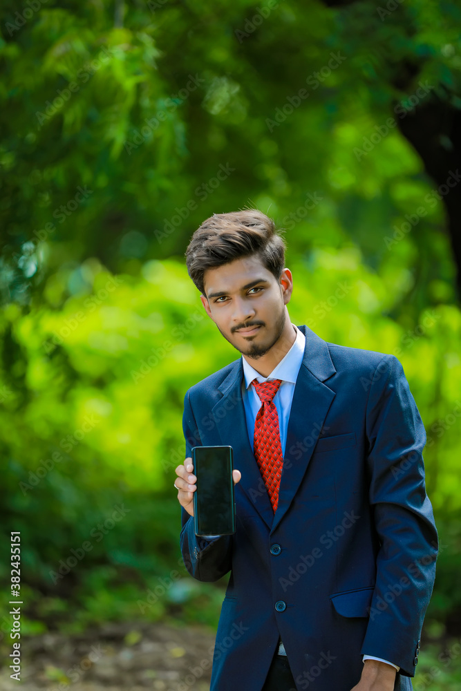 Happy businessman pointing finger on blank smartphone screen