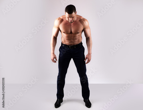 Strong man showing his perfect naked body. Bare torso. Sexy muscular guy. Full length.
