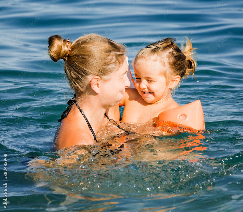 Mother with toddler girl in sea