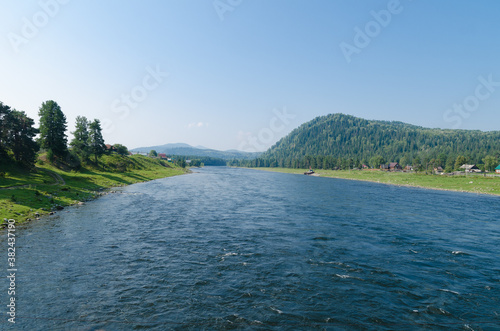 Fast mountain river on a sunny day. View from the bridge