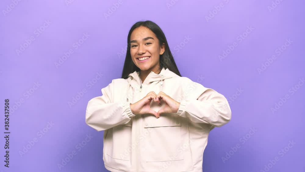Young mixed race indian woman smiling and showing a heart shape with hands Young mixed race indian woman smiling and showing a heart shape with hands