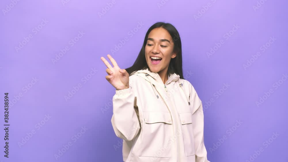 Young mixed race indian woman joyful and carefree showing a peace symbol with fingers Young mixed race indian woman joyful and carefree showing a peace symbol with fingers