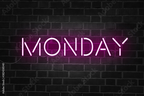 Monday purple neon sign on brick wall