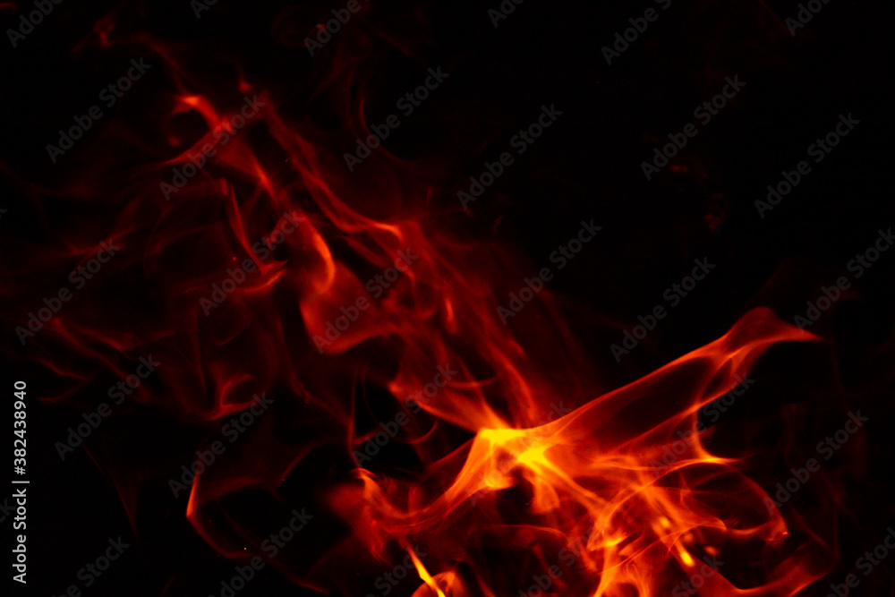 Fototapeta premium Abstract glowing background. Flames on a dark background with sparks and smoke.