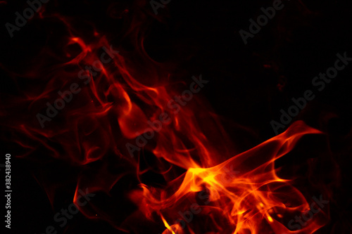 Abstract glowing background. Flames on a dark background with sparks and smoke.