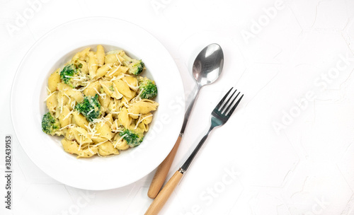 pasta with broccoli in creamy sauce in white plate