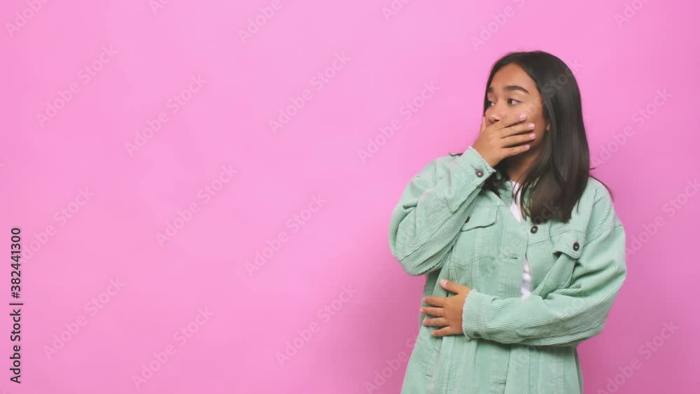 Young mixed race indian woman thoughtful looking to a copy space covering mouth with hand Young mixed race indian woman thoughtful looking to a copy space covering mouth with hand