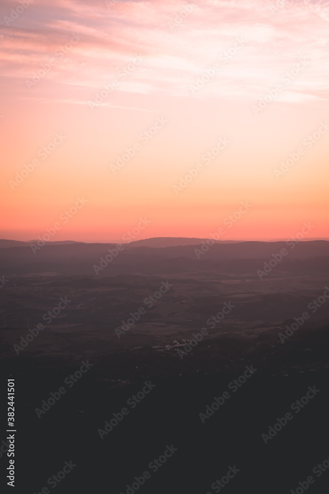 Sunset between mountains with clouds, colorful sky