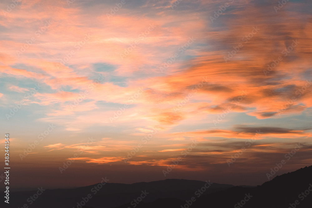 Sunset between mountains with clouds and colorful sky