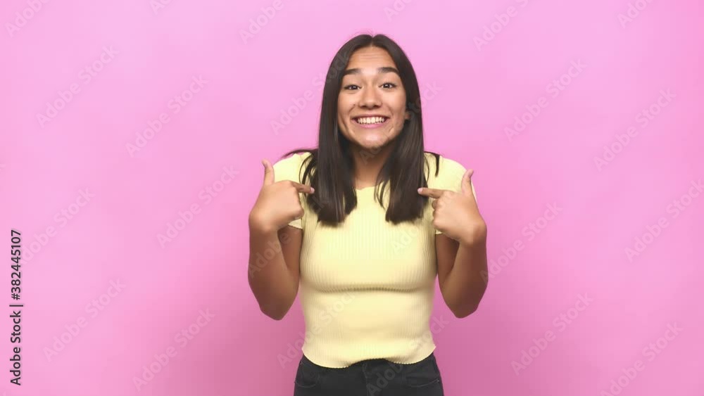 Young mixed race indian woman surprised pointing with finger, smiling broadly Young mixed race indian woman surprised pointing with finger, smiling broadly