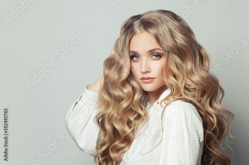 Pretty blonde woman with long healthy curly hair