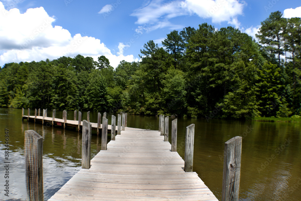 Fototapeta premium Wooden fishing pier jetting out over lake