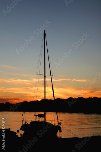 Silhouette of a sailing boat in the port at sunset. Selective focus.