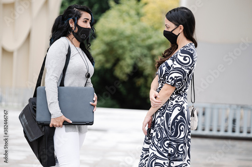 business women with masks maintaining a safe distance